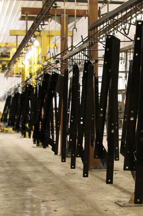 black coated parts hanging to dry