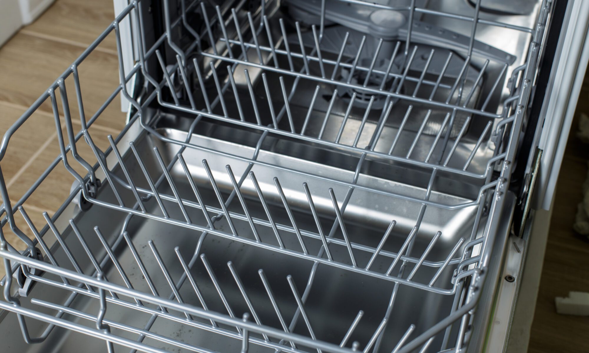An open dishwasher with the bottom rack pulled out.