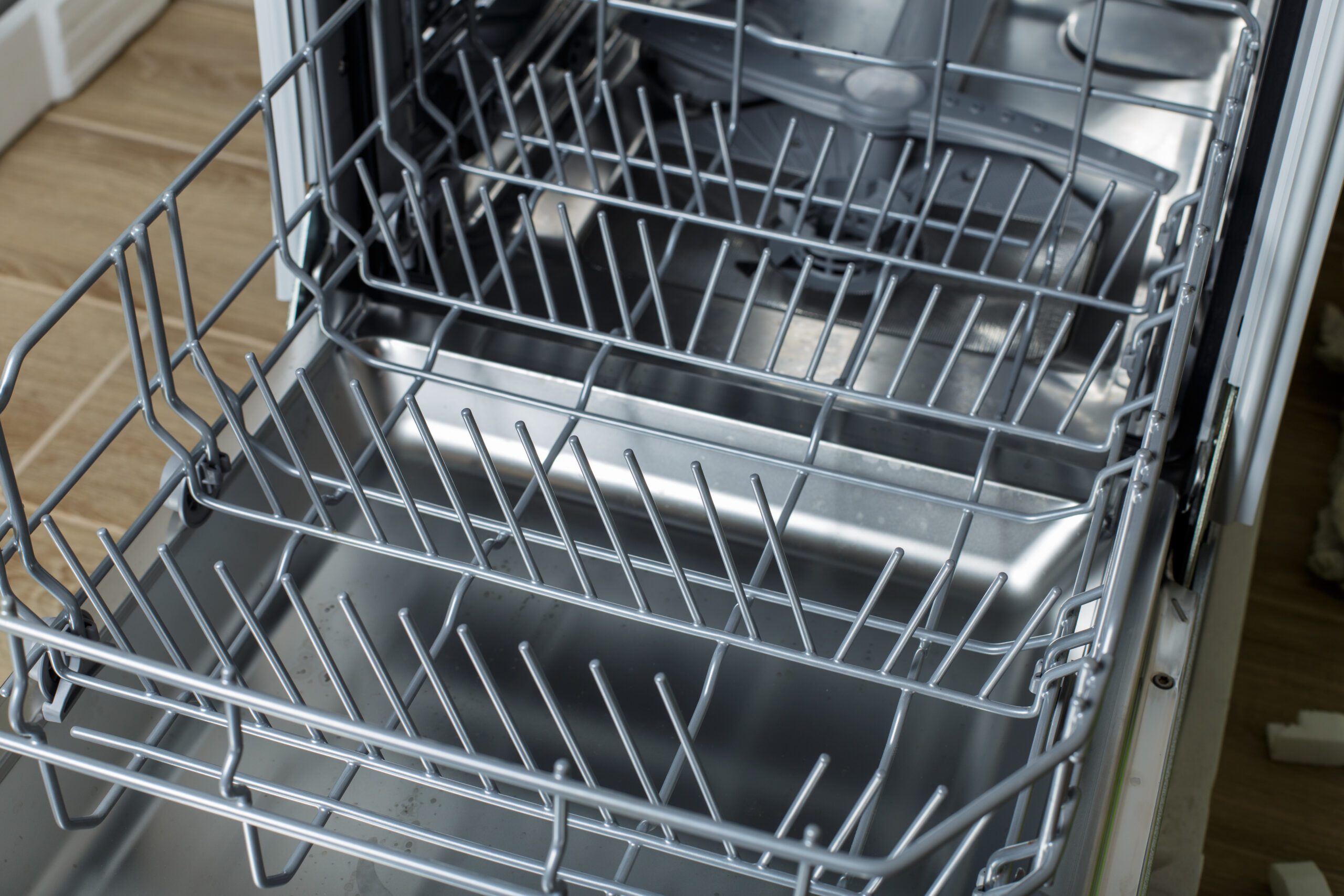 An open dishwasher with the bottom rack pulled out.