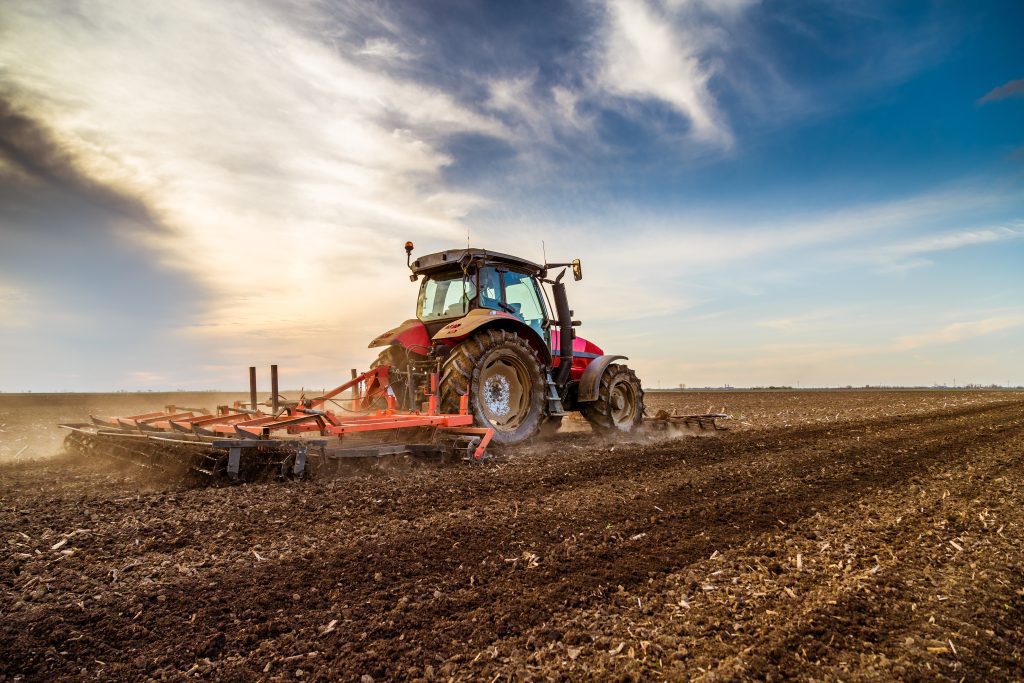 A tractor cultivating a field in spring.