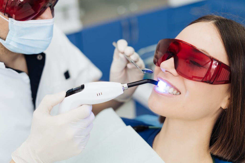 Close-up portrait of a female patient visiting a dentist for teeth whitening in a clinic.