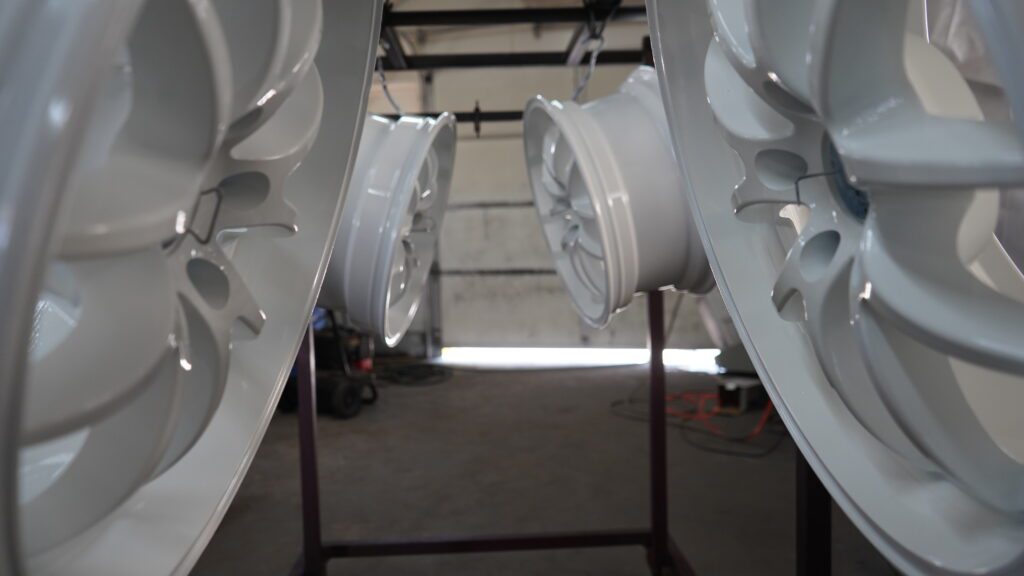 White wheels are on a powder coating line.