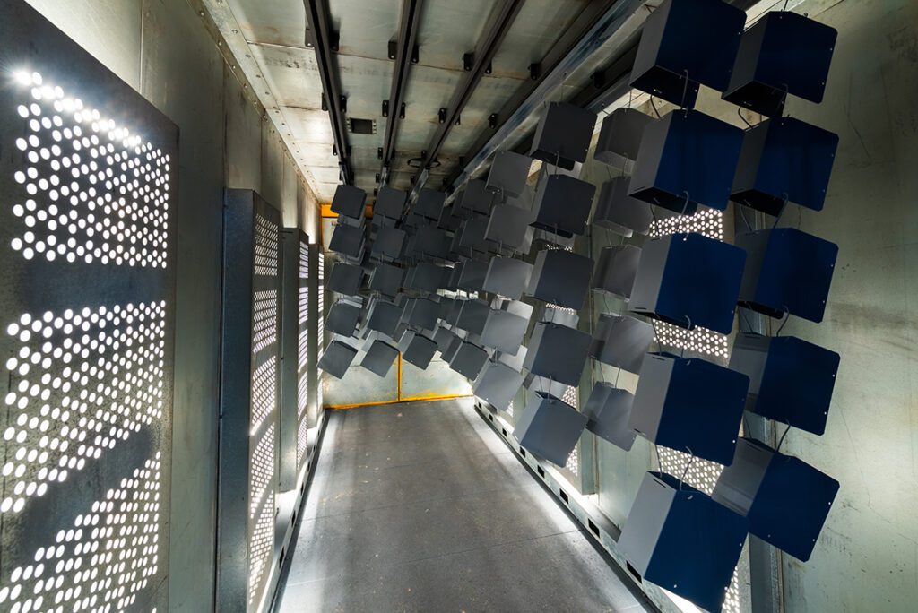 Black metal cubes drying in a curing oven.