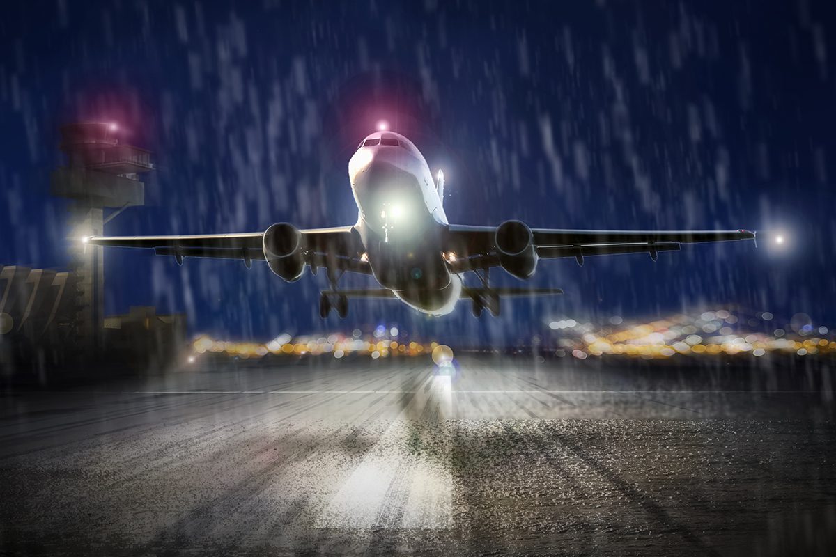 An airplane taking off in the rain in the evening.