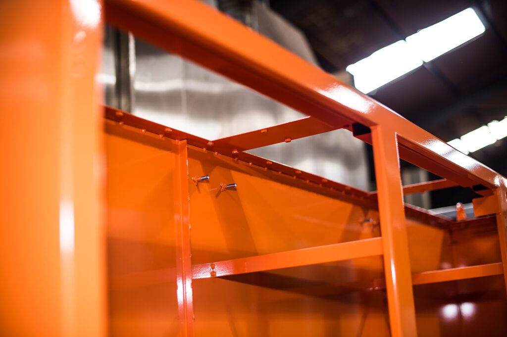 Orange powder coated metal machinery.