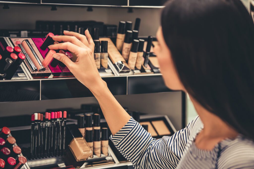A woman shopping for makeup from a retail display case